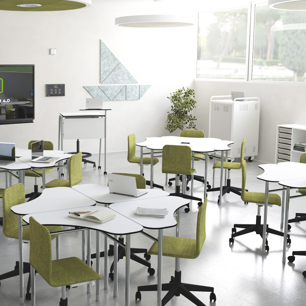 Sala de aula com mesas modulares, cadeiras verdes com rodas e computadores portáteis.
