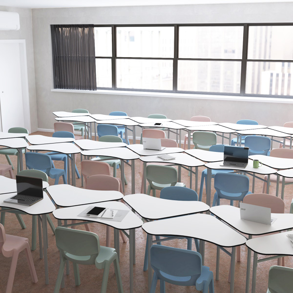 Sala de aula com mesas Desk 21 Boomerang agrupadas, cadeiras em tons pastel e computadores portáteis.