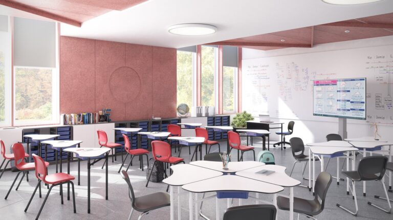 Sala de aula com mesas brancas, cadeiras de várias cores, estantes e quadros com anotações.