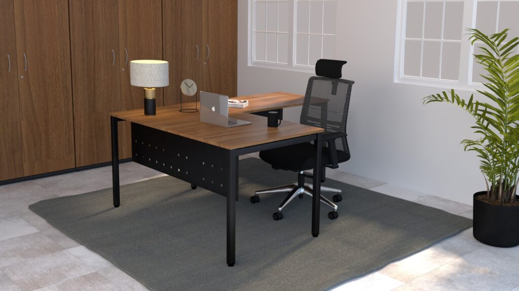 Escritório com mesa de madeira, computador portátil, candeeiro e armários junto à parede.