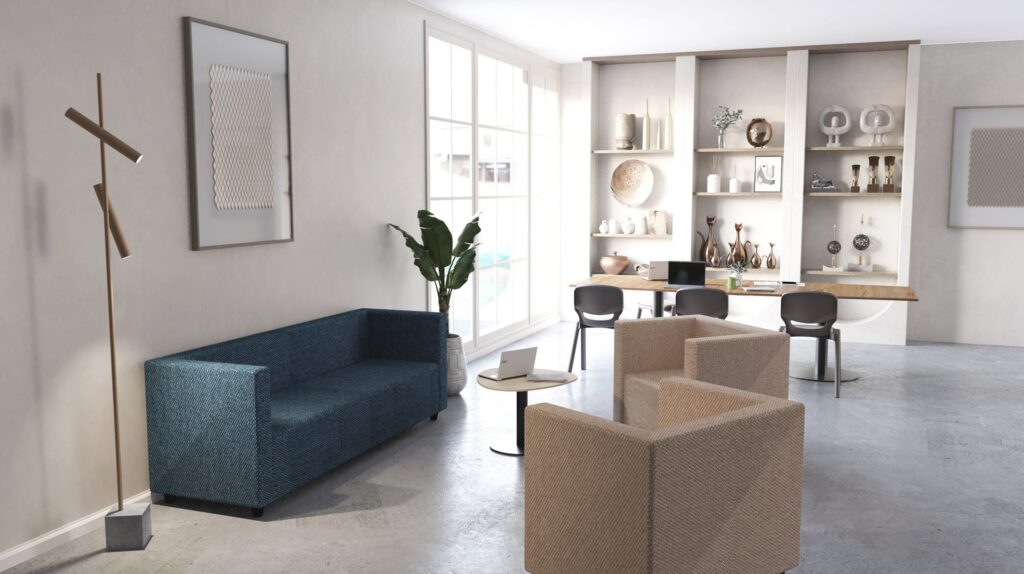 Zona de estar com sofá azul, cadeirões bege e mesa com computador portátil, junto a uma área de trabalho.