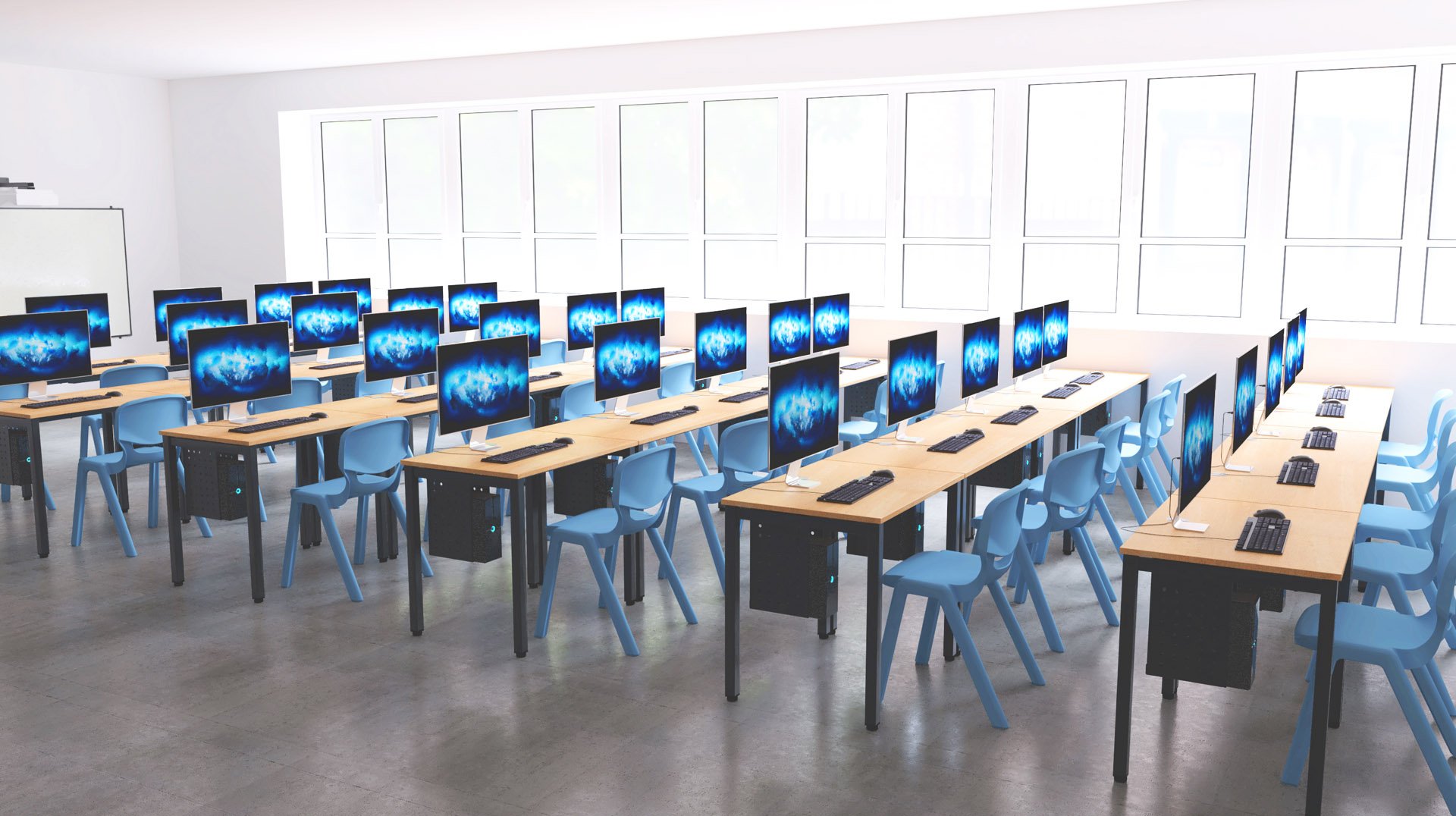 Sala de informática com mesas em filas, monitores, teclados, ratos e cadeiras azuis.