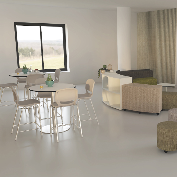 Espaço com mesas redondas, cadeiras, plantas e assentos estofados junto a um balcão branco.