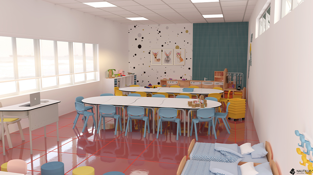 Sala infantil com mesas, cadeiras pequenas, brinquedos e canto de leitura com almofadas.