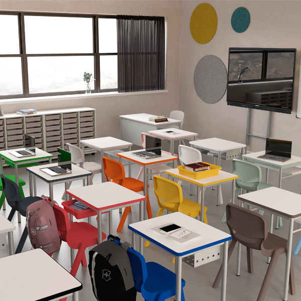 Sala de aula com mesas e cadeiras de várias cores, computadores portáteis, mochilas e arrumação.