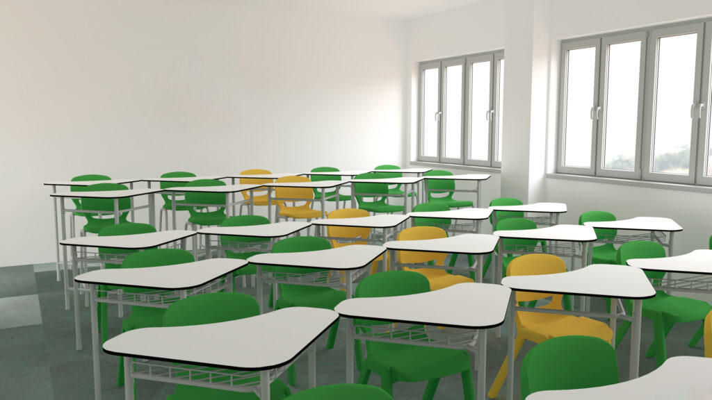 Sala com mesas em filas e cadeiras verdes e amarelas junto a grandes janelas.