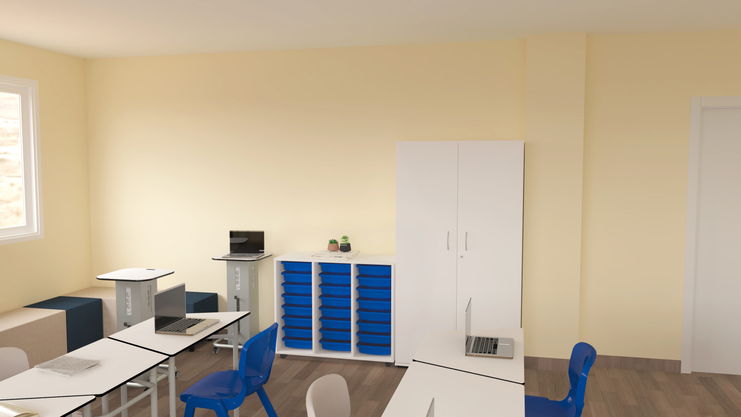 Sala com mesas brancas, cadeiras azuis, computadores portáteis e móvel com tabuleiros azuis.