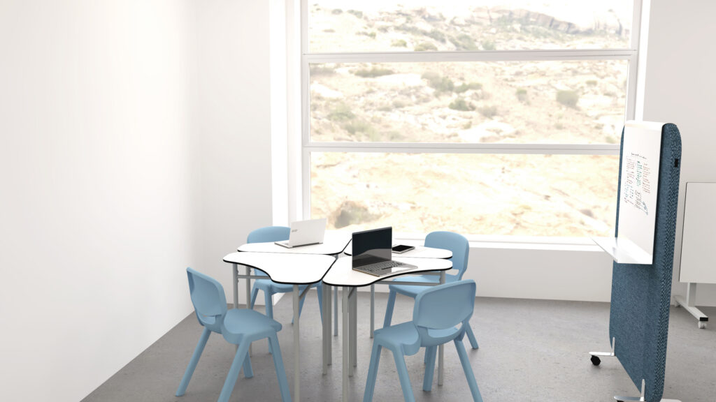 Sala de reuniões com mesa branca, cadeiras azuis, computadores portáteis e quadro branco.
