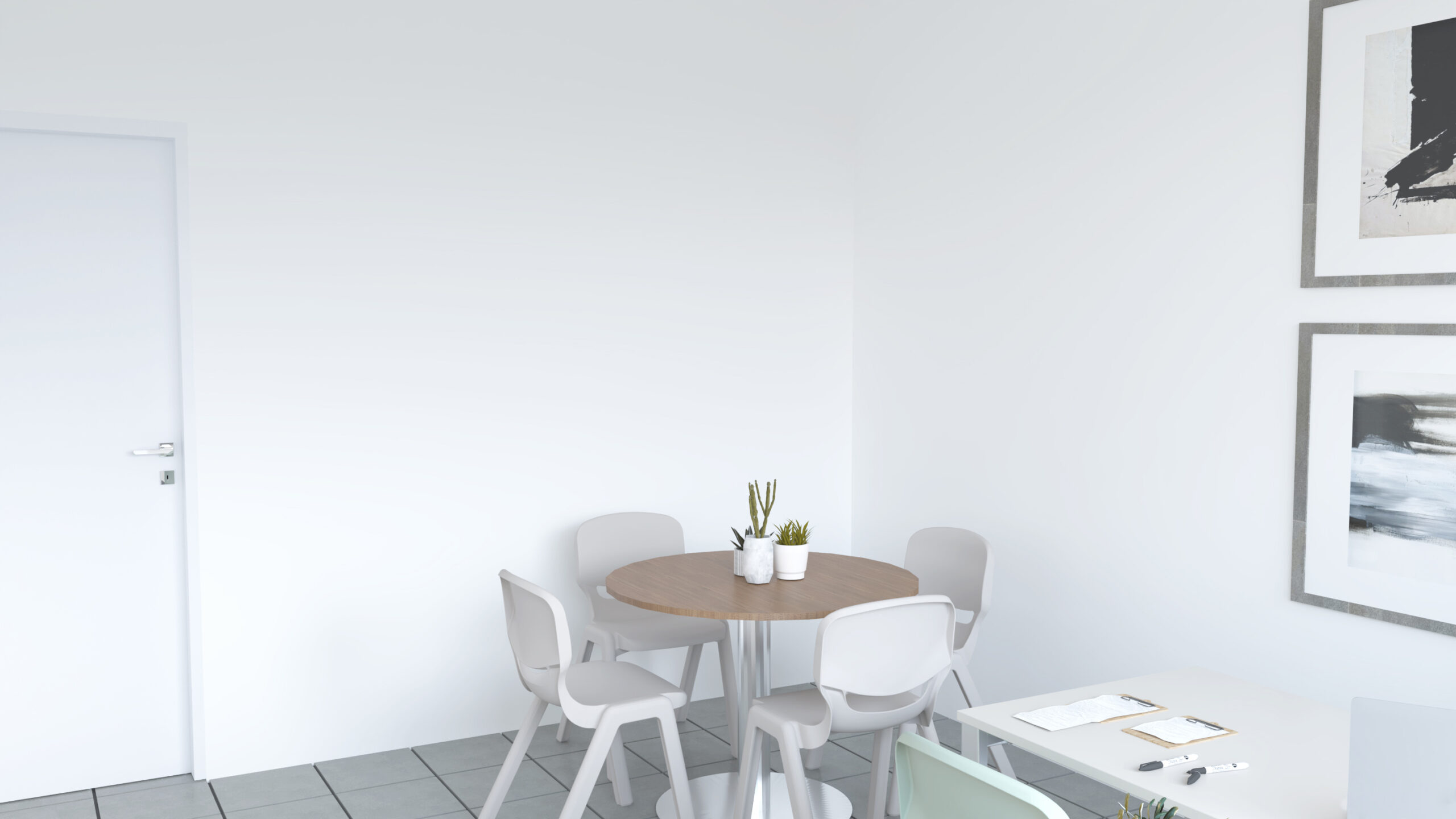 Sala com mesa redonda de madeira, cadeiras brancas e uma mesa de trabalho com documentos.