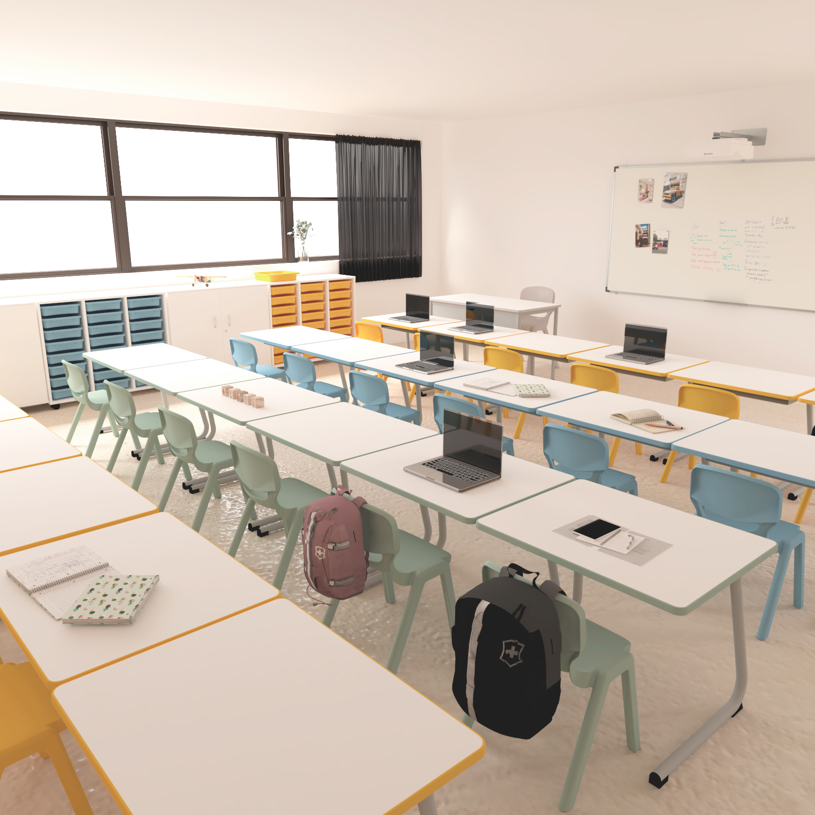 Sala de aula com computadores portáteis, livros e mochilas nas mesas e quadro com desenhos.