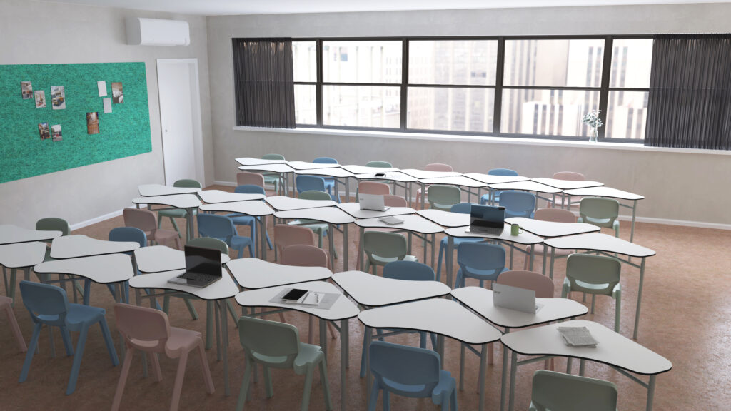 Sala com mesas brancas em filas, cadeiras em tons pastel e computadores portáteis.