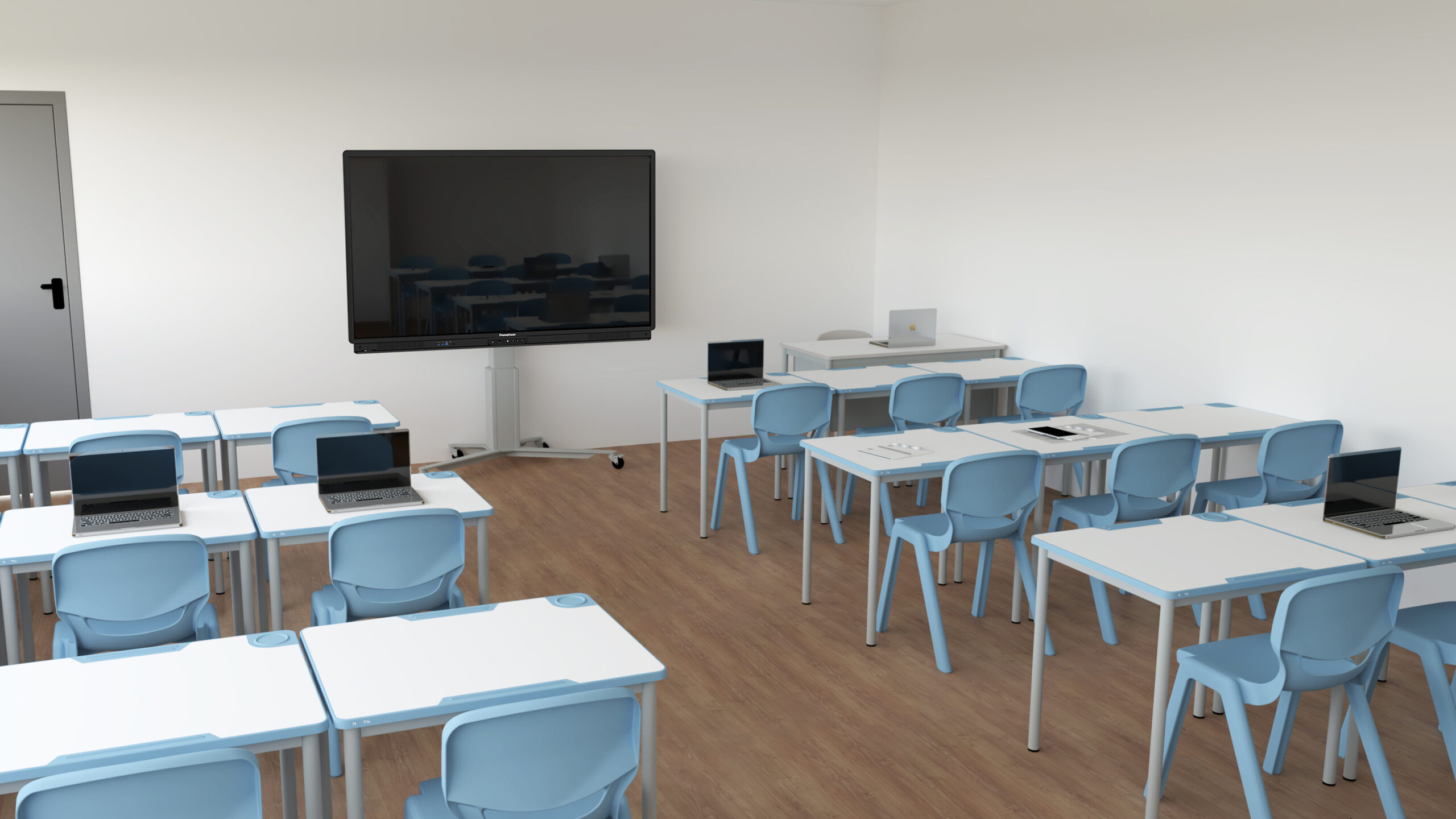 Sala com mesas brancas, cadeiras azuis-claras, computadores portáteis, tablets e ecrã.